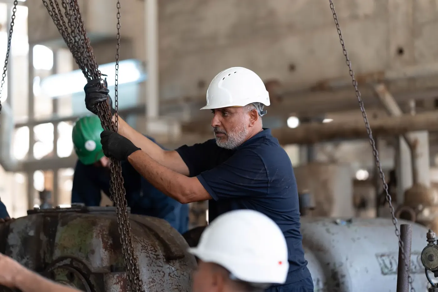 Workers positioning generator equipment during installation